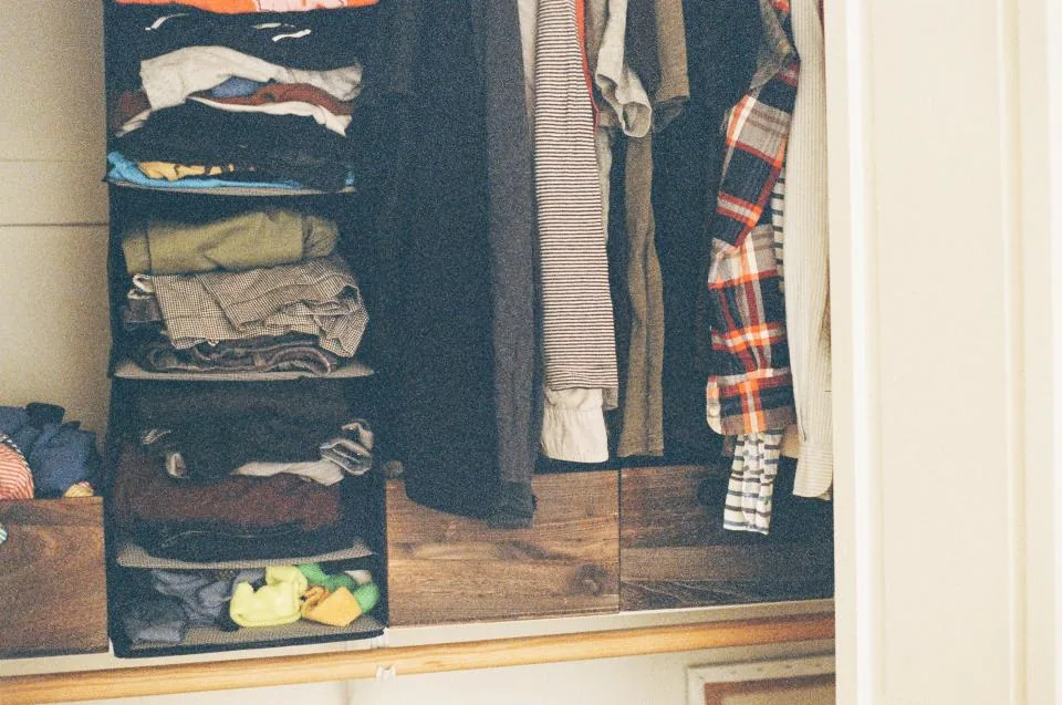 Folded and hanging clothes in a wardrobe